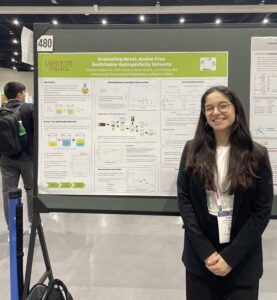 Female student stands in front of academic research poster