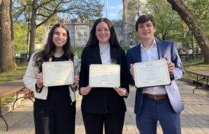 3 students stand outside on Lehigh University campus holding awards