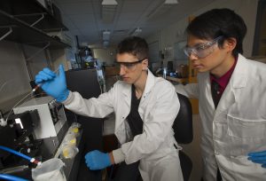 Male student in lab with professor