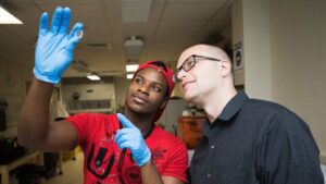 Male student in lab with male professor.